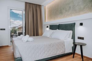 a bedroom with a large bed with white pillows at ILIADA Boutique Rooms in Faliraki