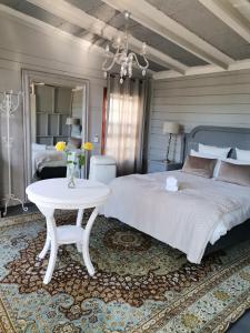 a bedroom with a large bed and a table at De Oude Schuur in Stellenbosch