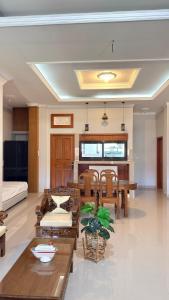 a large living room with wooden tables and chairs at Hideaway in Amed