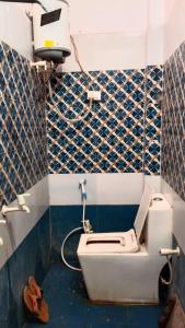 a bathroom with a toilet and a camera on the wall at Pandeyji stay in Ayodhya