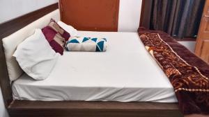 a white bed with pillows on top of it at Pandeyji stay in Ayodhya