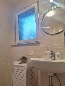 a bathroom with a sink and a mirror at Studio Laura in Ičići