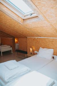 a bedroom with two white beds and a skylight at The White Hill Guesthouse in Yeroẖam