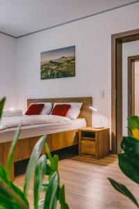 a bedroom with a bed and a nightstand and a bed sidx sidx sidx sidx at Malomfészek Apartman in Tapolca