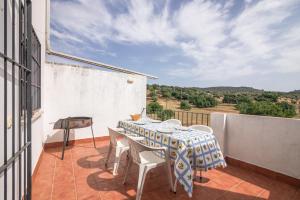 a patio with a table and chairs on a balcony at El Corralon de Severo in Hinojales