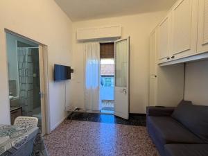 a living room with a couch and a door with a window at B&B Elisir in Albenga