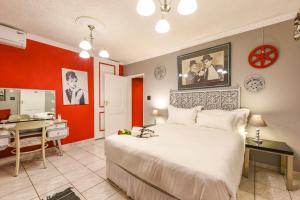 a bedroom with a large white bed and a desk at Villa Simonne in Johannesburg