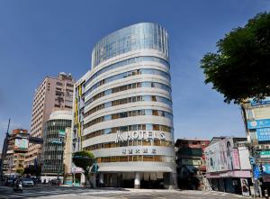 a tall glass building with a sign on it at K Hotel - Yunghe in Yonghe