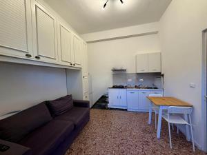 a living room with a couch and a table and a kitchen at B&B Elisir in Albenga