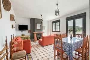 a living room with a table and chairs and a tv at El Corralon de Severo in Hinojales