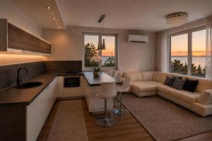 a kitchen and living room with a couch and a table at Marcelo Deluxe Apartment in Tihany