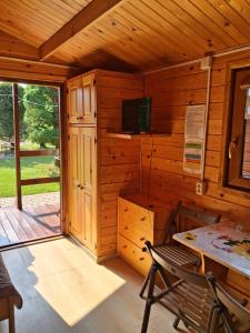 a wooden cabin with a table and a television in it at Zielony Zakątek domki i pokoje 661-038-537 in Polańczyk