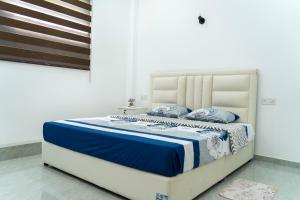 a bed with blue and white blankets and pillows at JY Apartments in Negombo