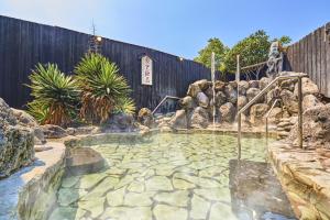 a swimming pool in a yard with a fence at Ooedo Onsen Monogatari Premium Hotel Fugetsu in Beppu