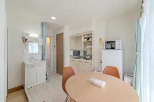 a kitchen and dining room with a table and a refrigerator at Mary's Room Hakata in Sumiyoshi +56 photos