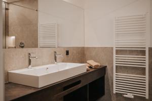 a bathroom with a white sink and a mirror at Montoni Chalets in Prato allo Stelvio +41 photos