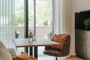 a living room with a table and a chair at Montoni Chalets in Prato allo Stelvio