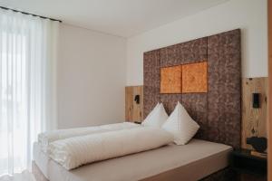 a bedroom with a large bed with white sheets at Montoni Chalets in Prato allo Stelvio
