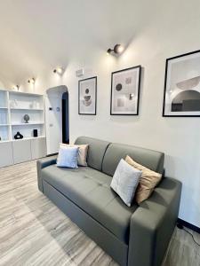 a living room with a couch with pillows on it at Norcia Stylish Apartment in Norcia