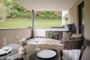 a patio with a table and chairs and a large window at Montoni Chalets in Prato allo Stelvio