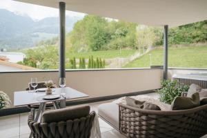 a balcony with a table and chairs and a large window at Montoni Chalets in Prato allo Stelvio