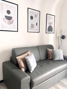 a living room with a gray couch with pillows at Norcia Stylish Apartment in Norcia