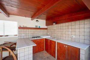 a kitchen with wooden cabinets and a sink and a counter at Casa del Riccio fronte mare in Mola di Bari +21 photos