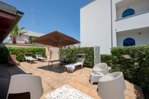 a patio with chairs and an umbrella next to a building at Casa del Riccio fronte mare in Mola di Bari