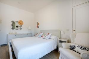 a white bedroom with two beds and a couch at Casa del Riccio fronte mare in Mola di Bari