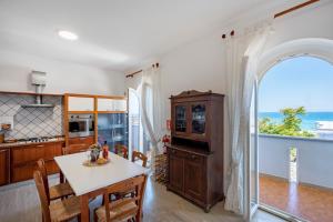 a kitchen and dining room with a table and a window at Casa del Riccio fronte mare in Mola di Bari