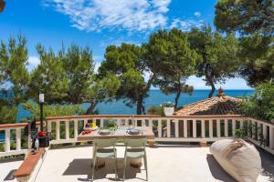 a patio with a table and chairs and the ocean at Seafront Collection - Bungalows and Villas in Aspra