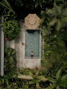 a person swimming in a pool with an umbrella at Kamaya - Private Villa with Pool in General Luna