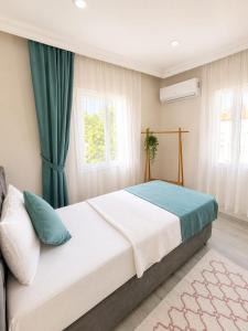 a bedroom with a large bed with green curtains at Apart Portakal Çiçeği in Kaş