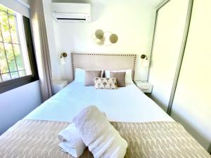 a bedroom with a bed with white sheets and pillows at Wave & Garden Riviera - EaW Homes in Mijas Costa +45 photos