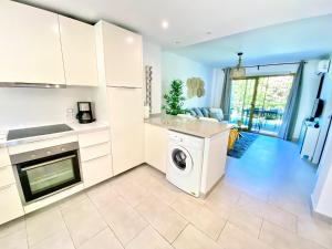 a kitchen with white cabinets and a washer and dryer at Wave & Garden Riviera - EaW Homes in Mijas Costa