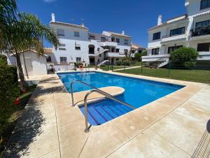 a swimming pool in front of a building at Wave & Garden Riviera - EaW Homes in Mijas Costa