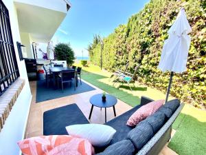 a living room with a couch and an umbrella at Wave & Garden Riviera - EaW Homes in Mijas Costa