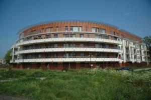 a large building with a car parked in front of it at Słoneczny Hel in Hel