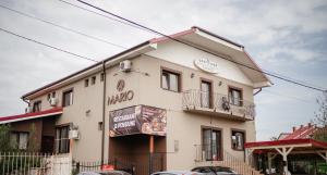 a large white building with a sign on it at Pensiunea Mario in Beiuş