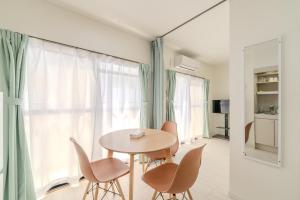 a dining room with a table and chairs and a window at Mary's Room Hakata in Sumiyoshi