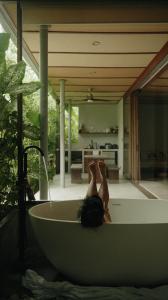 a woman laying in a bath tub in a house at Kamaya - Private Villa with Pool in General Luna +16 photos