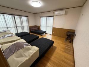 a hospital room with two beds and a desk at GATE80長崎 坂の街長崎 無人宿 完全セルフ 予約メッセージ欄確認要す スマートロック 暗証番号チェックイン 素泊まり専門 アメニティ持参で格安滞在 セコム24h監視 駐車場4台 in Nagasaki