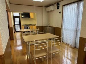 a room with a table and chairs and a kitchen at GATE80長崎 坂の街長崎 無人宿 完全セルフ 予約メッセージ欄確認要す スマートロック 暗証番号チェックイン 素泊まり専門 アメニティ持参で格安滞在 セコム24h監視 駐車場4台 in Nagasaki