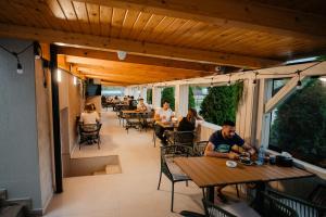 a group of people sitting at tables in a restaurant at Pensiunea Mario in Beiuş