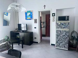 a living room with a tv and a cross on the wall at Appartamento Treviglio-centro in Treviglio