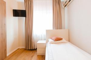 a bedroom with a bed and a window at Pensiunea Mario in Beiuş