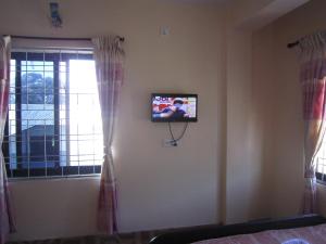 a television on a wall in a room with a window at Hotel Sunflower in Pokhara