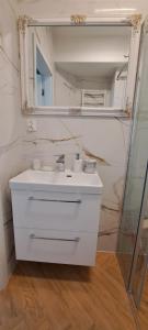 a white bathroom with a sink and a mirror at Wschód Słońca Ełk in Ełk
