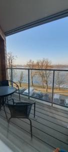 a balcony with a table and a view of the water at Wschód Słońca Ełk in Ełk