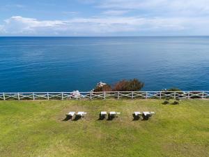 a group of benches sitting on a hill overlooking the ocean at Seafront Collection - Bungalows and Villas in Aspra
